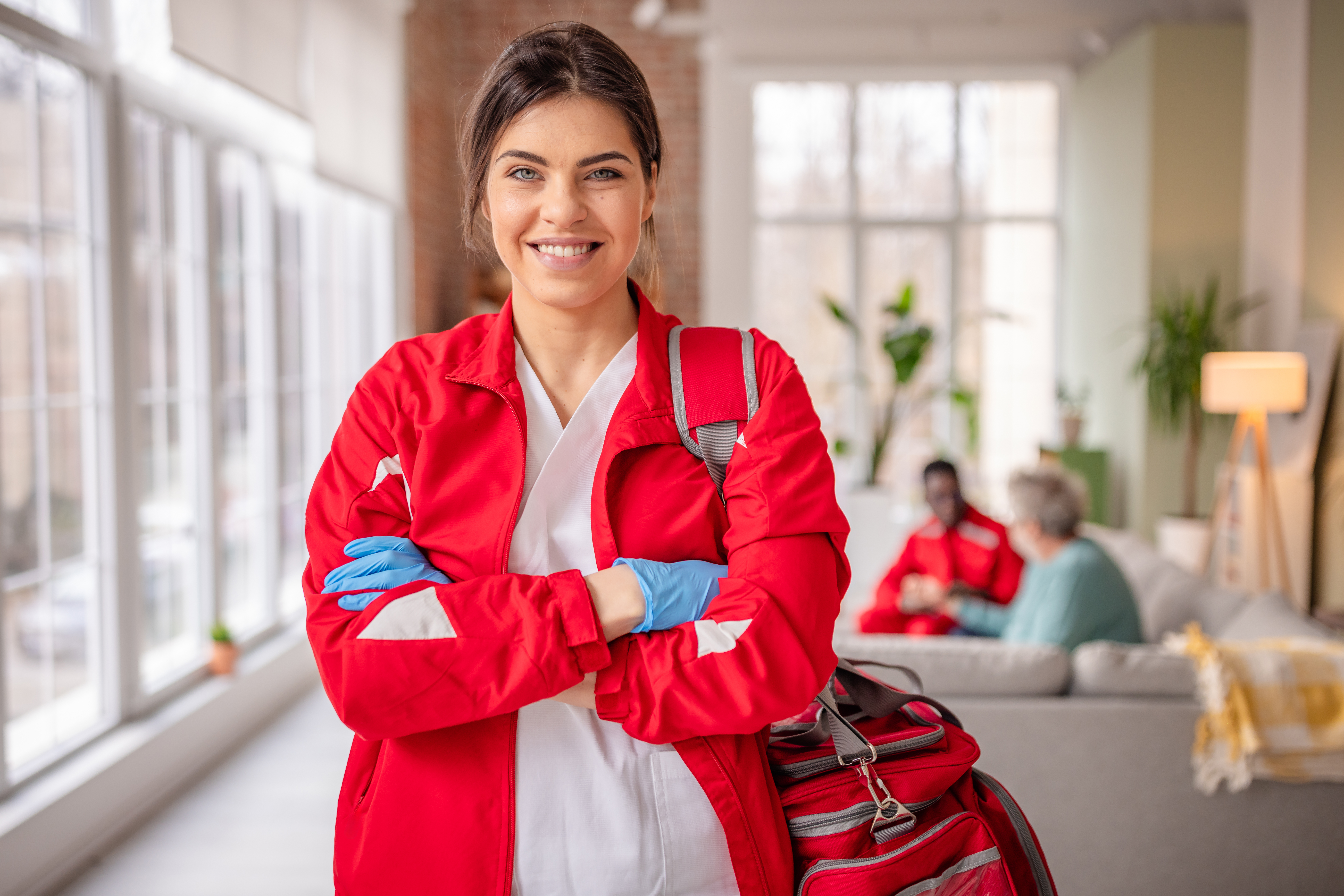 Person in red uniform with bag.